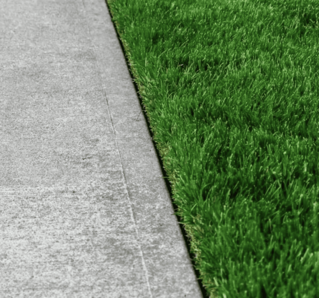 Lawn edging installation in Billings, MT, showcasing neat separation between grass and concrete.